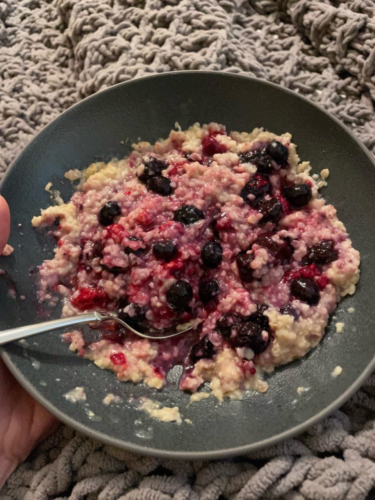 A bowl of oatmeal topped with mixed berries.